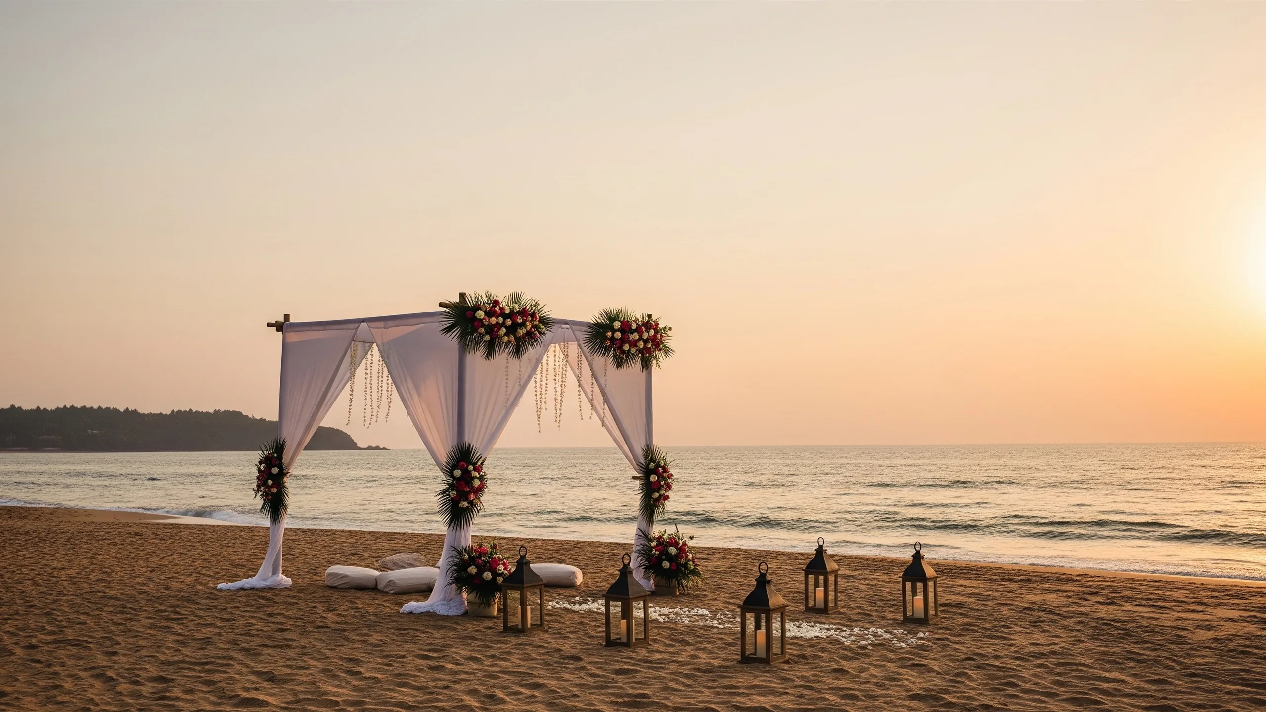 An atmospheric wide view of a Goa beach at sunset with a decorated wedding canopy and lanterns on the sand, the calm ocean behind, true-to-life ambience, styled view